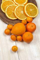 Fresh ripe citrus. Lemons, kumquat and oranges on wooden table