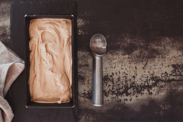 Homemade ice cream in frozen metallic tray on rustic surface