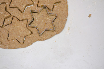 Cutting Christmas cookies from rye dough with star shaped cutter