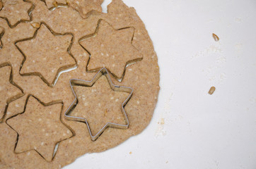 Cutting Christmas cookies from rye dough with star shaped cutter