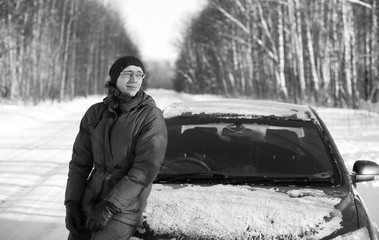 Black and white photo of winter rural road in forest in sunny da