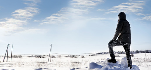 silhouette of man standing in winter field in sunny day