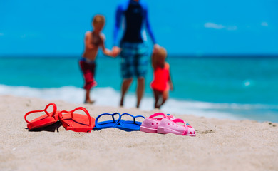 father with son and daughter walking at beach