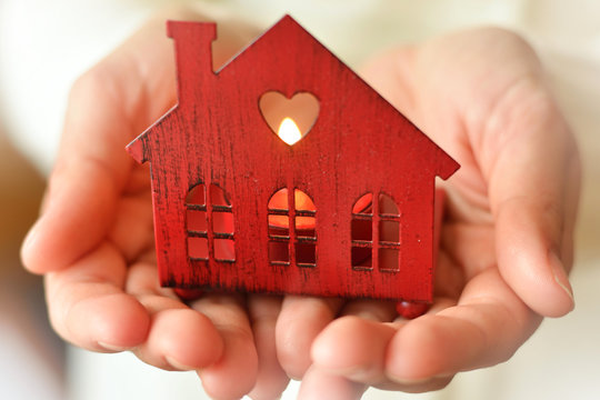 Warm and cozy miniature house in female hands. Care and love.