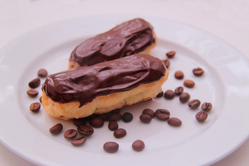 Chocolate eclairs on plate on white background
