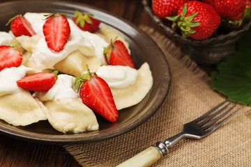 Delicious dumplings with fresh strawberries served with whipped