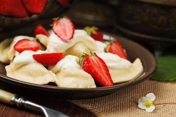 Delicious dumplings with fresh strawberries served with whipped
