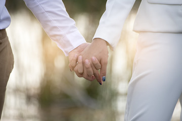 Couple love standing hand in hand,sunset background.