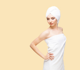 Young, beautiful and natural woman wrapped in towel isolated on