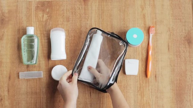 hands packing cosmetic bag for travel