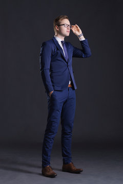 Young and confident business man. Businessman in suit over dark background.