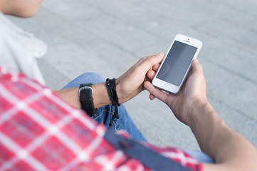 Man in casual clothing feels comfortable sitting on the stairs holding a phone.