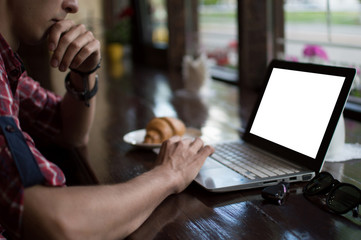 Young man freelancer working from a cafe with a laptop, hipster guy using modern laptop computer while working in a vintage loft, close-up of male hands.