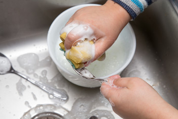 boy washing dishes in the kitchen