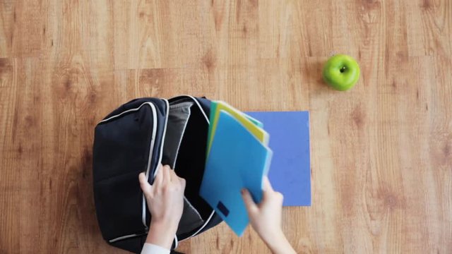 hands packing schoolbag