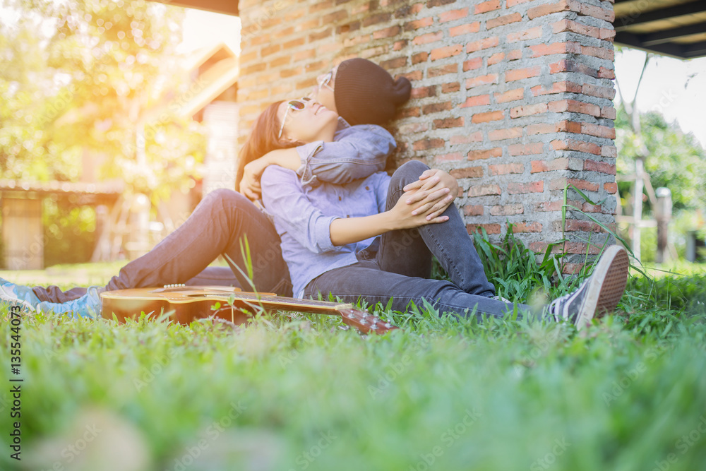 Poster Hipster man playing guitar for his girlfriend outdoor against br