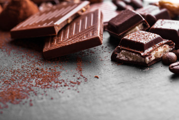 Delicious chocolates and spices on a black background.