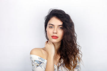 Beauty portrait of young adorable fresh looking brunette woman with healthy curly hair bare shoulder. Emotion and facial expression concept.