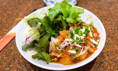Salmon salad with fresh vegetables in the white bowl