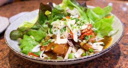 Salmon salad with fresh vegetables in the white bowl