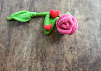 Valentines day pink rose with red heart on wooden background, lo