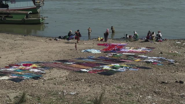 People washing clothes in te river, Mandalay, Myanmar