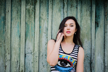 Fototapeta premium Brunette model girl at dress with stripes background cian wooden
