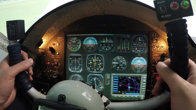 Flight simulator control panel, male hands holding airplane steering wheel