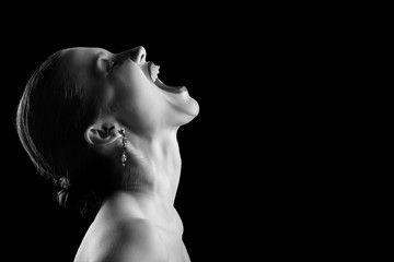angry nude girl screaming up on black background