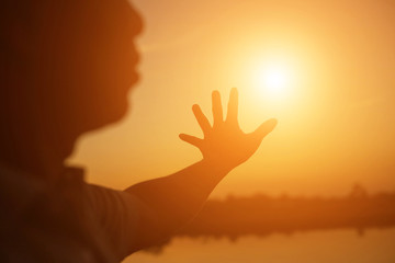 hands forming a heart shape with sunset silhouette