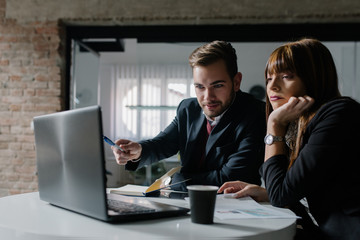 Two young people in the office concentrated on their work