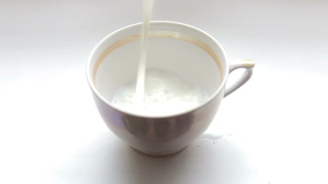 Is poured milk into the cup
