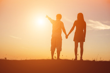  silhouette of a man and woman holding hands with each other, wa