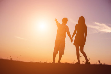  silhouette of a man and woman holding hands with each other, wa