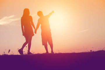  silhouette of a man and woman holding hands with each other, wa