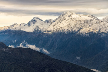 Beautiful dramatic winter mountain landscape of the Main Caucasus ridge with scenic snowy mountain peaks and cloudy sky