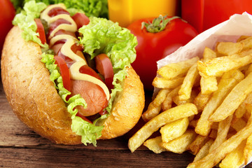 Hotdog with french fries on wooden plank