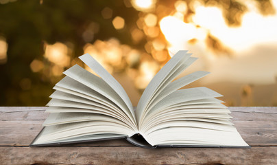 open book on wood table outdoors