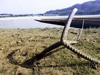 A steel anchor along the shore