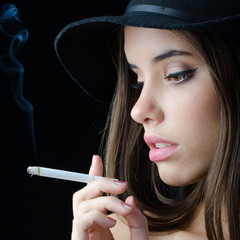 Portrait of the beautiful elegant girl smoking cigarette isolated on black