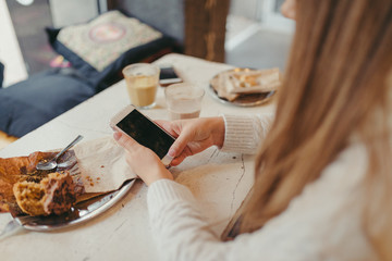 hands of a woman holding a smart phone in cafe