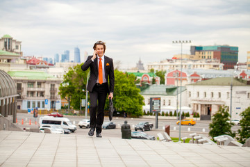 Young successful businessman calling by phone