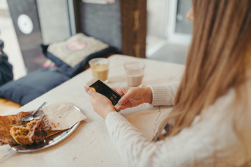 hands of a woman holding a smart phone in cafe