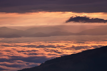 Sunrise in the mountains above the clouds