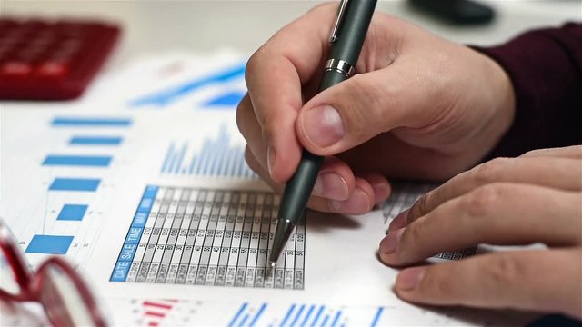 Trader Man With Pen In Hand And Analyzes Stock Exchange Statistics
