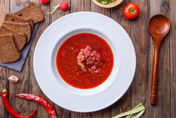 Beet soup in white plate with vegetables