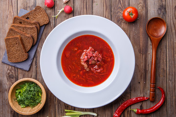 Beet soup in white plate with vegetables