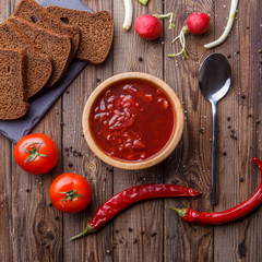 Beet soup in wooden plate with vegetables