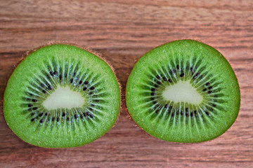 Closeup of two kiwi halves on a wooden table
