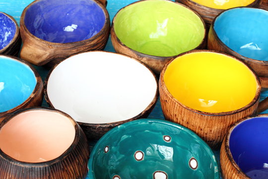 Many different bright multicolored ceramic bowls and cups handcrafted. Background texture